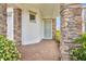 Inviting front porch with stone pillars, tiled walkway, and a stylish entry door at 13282 Bromborough Dr, Orlando, FL 32832