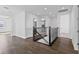 Bright upstairs hallway with wood floors and wrought iron staircase railing at 13282 Bromborough Dr, Orlando, FL 32832