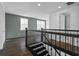 Bright upstairs hallway with wood floors and wrought iron staircase railing at 13282 Bromborough Dr, Orlando, FL 32832