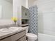 Bathroom with a combination tub and shower with a patterned shower curtain and storage cabinet at 1379 Winter Gray Cir, Deltona, FL 32738