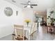 A dining room with white table and chairs is complemented by a decorative mirror and an overhead ceiling fan at 1379 Winter Gray Cir, Deltona, FL 32738