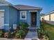 Close-up of the front entry, showing the dark door, landscaping, and well-manicured flowerbeds at 1379 Winter Gray Cir, Deltona, FL 32738