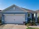 Charming single-story home featuring a 2-car garage, blue exterior, and beautifully landscaped front yard at 1379 Winter Gray Cir, Deltona, FL 32738