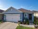 Inviting one-story home featuring a 2-car garage, a well-kept lawn, and colorful garden beds at 1379 Winter Gray Cir, Deltona, FL 32738