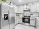 Bright kitchen featuring stainless steel appliances, white cabinets, and tiled floors at 1379 Winter Gray Cir, Deltona, FL 32738
