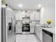 Bright kitchen featuring stainless steel appliances, white cabinets, and tiled floors at 1379 Winter Gray Cir, Deltona, FL 32738