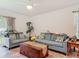 A well-lit living room featuring two gray sofas, wood floors, plants, and a view to the outside at 1379 Winter Gray Cir, Deltona, FL 32738
