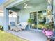 Covered patio with seating, ceiling fan and sliding glass door access to the home at 1379 Winter Gray Cir, Deltona, FL 32738