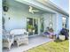 Covered patio with seating, ceiling fan and sliding glass door access to the home at 1379 Winter Gray Cir, Deltona, FL 32738
