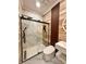 Modern bathroom featuring a glass enclosed shower with black hardware and marble tile at 1407 Water Lilly Ln, Kissimmee, FL 34744