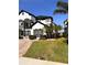 A partial view of a two story home featuring black window trim, dark roof, and well manicured landscaping at 1407 Water Lilly Ln, Kissimmee, FL 34744