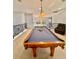 Well-lit game room showcasing a pool table with accessories and a leather chair at 1407 Water Lilly Ln, Kissimmee, FL 34744