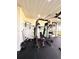 A fully equipped home gym with weightlifting station, weights, and an overhead fan for ventilation at 1407 Water Lilly Ln, Kissimmee, FL 34744