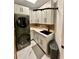 Well-lit laundry room featuring modern appliances, white cabinetry, and a hanging rack for drying clothes at 1407 Water Lilly Ln, Kissimmee, FL 34744