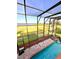 Enjoy the screened in pool with amazing lake view and a rock waterfall feature at 1407 Water Lilly Ln, Kissimmee, FL 34744