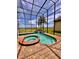 Enjoy a screened in pool with spa and a rock waterfall feature, perfect for relaxation at 1407 Water Lilly Ln, Kissimmee, FL 34744