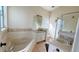 Well-lit bathroom with double sinks, a large soaking tub, and a glass-enclosed shower at 16732 Glenbrook Blvd, Clermont, FL 34714