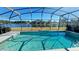 Sparkling pool overlooking a serene lake, enclosed by a screened lanai for privacy at 16732 Glenbrook Blvd, Clermont, FL 34714
