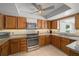 Charming kitchen featuring wood cabinets, granite countertops, and stainless steel appliances at 1700 E Clinton Dr, St Cloud, FL 34769