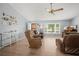 Cozy living room with wood floors, a ceiling fan, and a bright bay window at 1700 E Clinton Dr, St Cloud, FL 34769