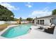 Inviting backyard pool with a lounging area, a playset and well-maintained grass at 1700 E Clinton Dr, St Cloud, FL 34769