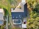 Aerial view of house with metal roof, pool, shed, lawn, and surrounding trees at 1849 Kings Point Blvd, Kissimmee, FL 34744