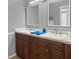 Bathroom features a double vanity, dark wood cabinets, white countertops, and two mirrors at 1849 Kings Point Blvd, Kissimmee, FL 34744