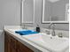Bathroom features a double vanity, dark wood cabinets, white countertops, and two mirrors at 1849 Kings Point Blvd, Kissimmee, FL 34744