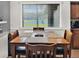 Bright dining area featuring a large window, wooden table with seating for four, and modern decor at 1849 Kings Point Blvd, Kissimmee, FL 34744
