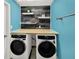 Stylish laundry room with modern washer and dryer, butcher block countertop, and decorative floating shelves at 1849 Kings Point Blvd, Kissimmee, FL 34744