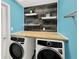 Modern laundry room with butcher block countertop, floating shelves, and contemporary design elements at 1849 Kings Point Blvd, Kissimmee, FL 34744
