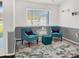 Stylish seating area with two blue chairs, ottoman, and decorative trunks by a bright window at 1849 Kings Point Blvd, Kissimmee, FL 34744