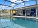 Screened-in pool area with a blue pool, travertine deck, covered patio, and outdoor seating at 1849 Kings Point Blvd, Kissimmee, FL 34744