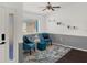 Sitting area features blue accent chairs and a modern rug, illuminated by natural light at 1849 Kings Point Blvd, Kissimmee, FL 34744