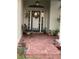 Inviting front porch featuring a decorative door, lush greenery, and classic brick pavers at 1920 Triumfo Cir, Kissimmee, FL 34744