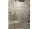 Modern shower featuring glass enclosure, sleek fixtures, a built-in seat, and contemporary tile design at 1920 Triumfo Cir, Kissimmee, FL 34744