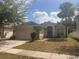 Charming single-story home features a two-car garage, palm tree and a well-maintained lawn at 1948 Bridgeview Cir, Orlando, FL 32824