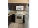 The kitchen features dark cabinets, granite countertops, and modern white appliances at 228 Scottsdale Sq # 228, Winter Park, FL 32792