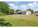 Back exterior view featuring the large yard and enclosed back patio at 2374 Eagle Trace Dr, Kissimmee, FL 34746