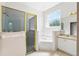 Bright bathroom featuring a walk-in shower, soaking tub, single vanity, and natural lighting at 2374 Eagle Trace Dr, Kissimmee, FL 34746