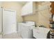 Well-equipped laundry room with modern washer, dryer, and ample storage cabinets above at 2374 Eagle Trace Dr, Kissimmee, FL 34746