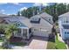 Charming two-story home with a brick driveway, front porch, and lush landscaping at 2487 Empress Dr, Kissimmee, FL 34741
