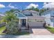Inviting two-story home with a brick driveway, two-car garage, and well-manicured lawn at 2487 Empress Dr, Kissimmee, FL 34741
