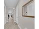Neutral-toned hallway featuring tile flooring and a decorative mirror at 2487 Empress Dr, Kissimmee, FL 34741