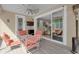 A covered patio features a seating area with striped cushions, sliding glass doors, and a ceiling fan at 2487 Empress Dr, Kissimmee, FL 34741