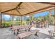 Covered outdoor picnic area with tables, ceiling fan, bar with seating and built-in stone grills at 2487 Empress Dr, Kissimmee, FL 34741