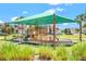 Community playground under a green canopy providing sun protection at 2487 Empress Dr, Kissimmee, FL 34741