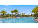 Community pool area featuring a splash pad, chairs, lounge chairs, and palm trees at 2487 Empress Dr, Kissimmee, FL 34741