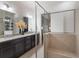 Bathroom showcasing dual sinks, granite countertops, a glass shower, and an adjoining bedroom at 2503 Yellow Brick Rd, St Cloud, FL 34772
