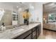 Bathroom featuring granite countertops, dual sinks, a glass shower, and adjacent bedroom at 2503 Yellow Brick Rd, St Cloud, FL 34772